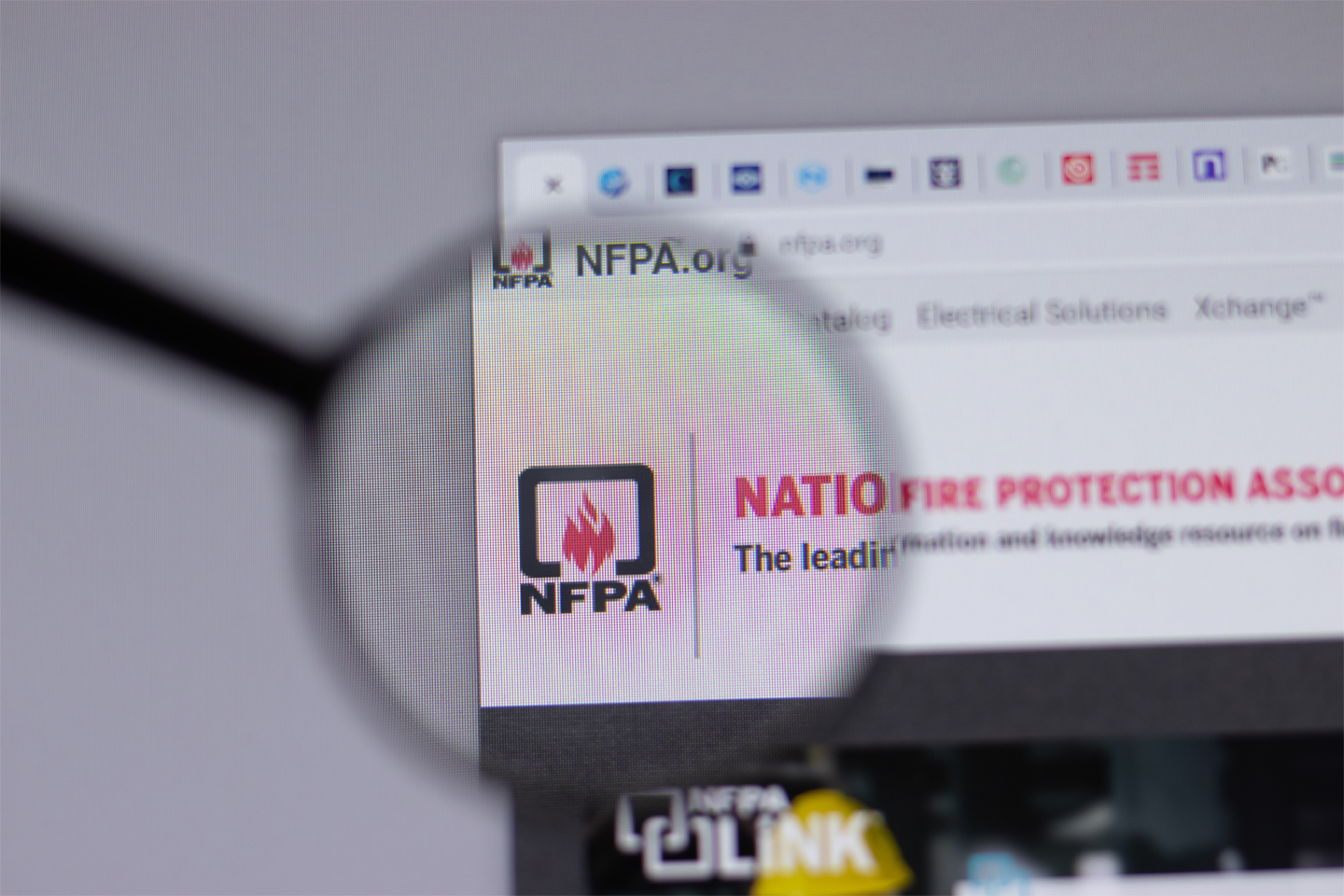 the NFPA website highlighted with a magnifying glass on an internet browser window